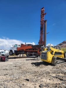 Drill truck next to heavy machinery